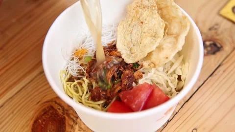 Putting water in for soto mie Stock Footage 272298480