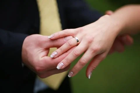 Putting on a wedding ring Stock Photos