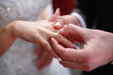 Putting on a wedding ring 스톡 사진