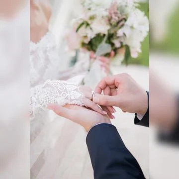 Putting on a wedding ring Stock Photos