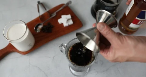 Putting whisky in glass cup with coffee Stock Footage 119425341