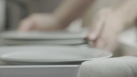 Putting white clean plates into drawer Stock Footage 336987728