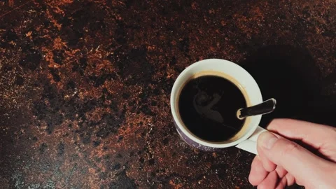 Putting a white cup of black coffee on a dark textured table Stock Footage 334884996