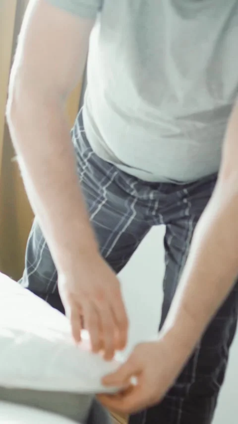 Putting a white fitted sheet or mattress protector on a bed Stock Footage 341858632