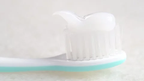Putting whitening toothpaste on a toothbrush on white background. Applying .. Stock Footage 284420642