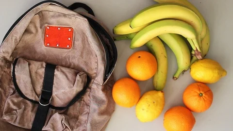 Puttingfruits into old backpack after grocery shopping Stock Footage 105585935
