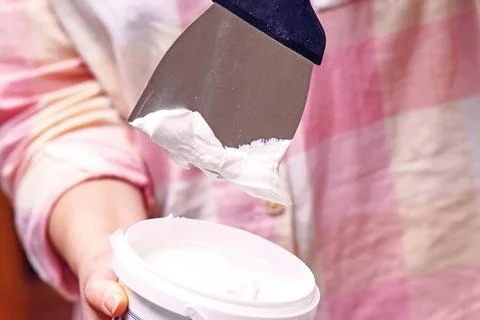 Putty from a jar to a spatula Stock Photos