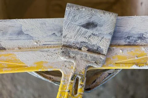 Putty knife in the worker place during apartment is under construction Stock Photos