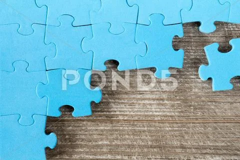 Puzzle on brown wooden surface Stock Photos