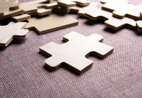 Puzzle elements on a texile background as a riddle Stock Photos