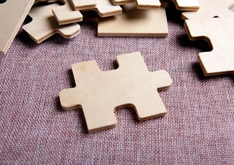 Puzzle elements on a textile background as a riddle Stock Photos