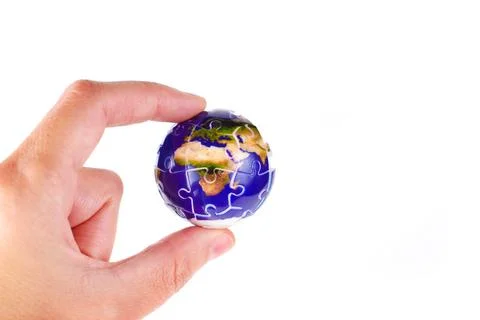 Puzzle Globe Held Between Fingers on White Stockfoto's