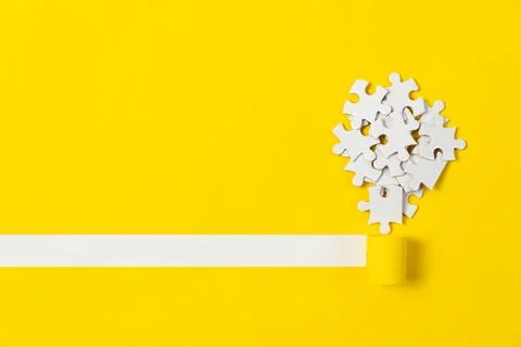Puzzle Lightbulb on Yellow Background Fotos de archivo