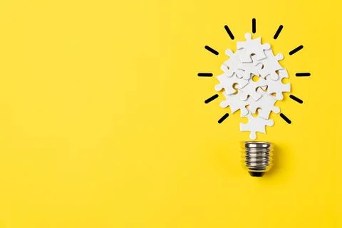 Puzzle Lightbulb on Yellow Background 写真素材
