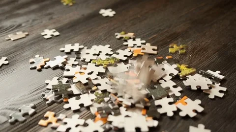 Puzzle parts falling on dark table Stock Footage 72491679
