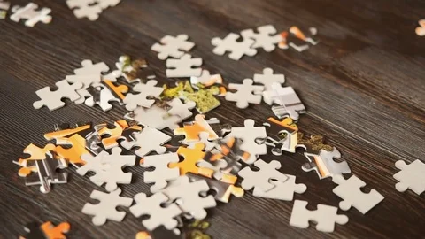 Puzzle parts falling on dark table Stock Footage 72492031