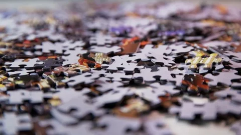 Puzzle parts falling on white table Video stock 74366027