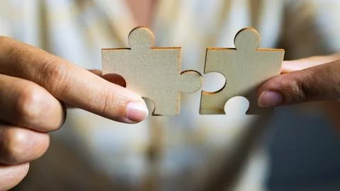 Puzzle piece connection creative collaboration indoor setting close-up view.. Stock Photos