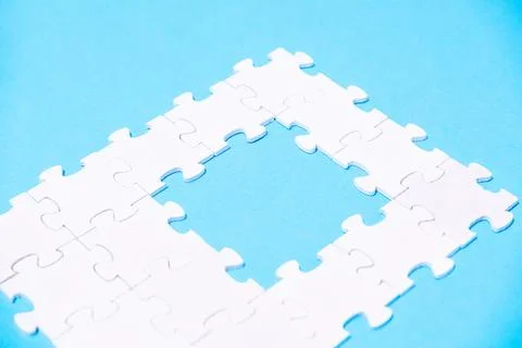 A puzzle piece is missing from a puzzle, leaving a gap in the middle 스톡 사진