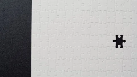 Puzzle pieces assembled black surface missing fragment closeup. Unsolved task Stock Footage 332307998