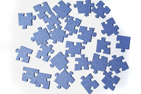 Puzzle pieces scattered on a white background. Stock Photos