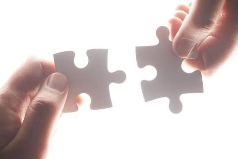 Puzzle, synergy and solution with hands of person on white background for Stock Photos