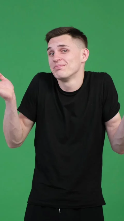 Puzzled And Joyful Man Spreading Arms And Shrug Shoulder On Green Background Stock Footage 274146377