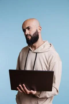 Puzzled arab man programming on laptop Stock Photos