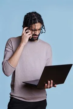 Puzzled arab programmer solving code problem on laptop Stock Photos