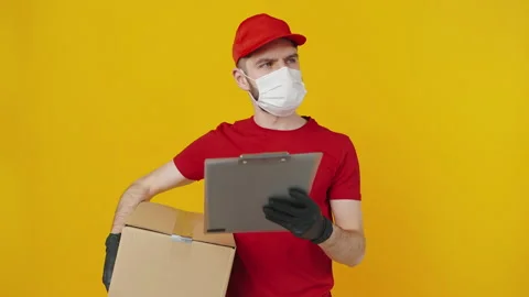 Puzzled delivery man with parcel box and clipboard looking around, searching 動画素材 149623972