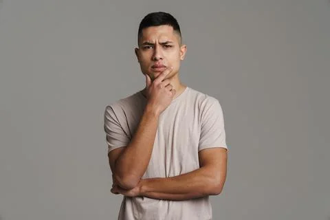 Puzzled handsome guy thinking and looking at camera Stock Photos