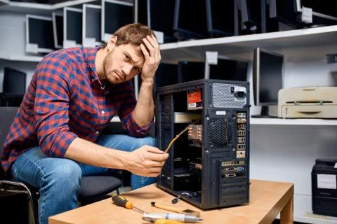Puzzled handsome man cannot solve the computer problem Stock Photos