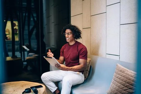 Puzzled hipster guy using digital tablet for making online banking Stock Photos