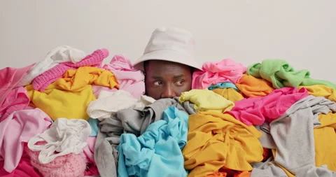 Puzzled indignant black man overwhelmed with household chores covered with giant Stock Footage 157336420