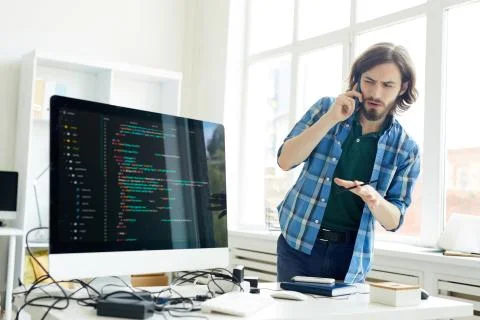 Puzzled IT specialist asking question to customer on phone Stock Photos