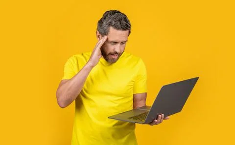 Puzzled man programmer isolated on yellow. man programmer on background. 스톡 사진