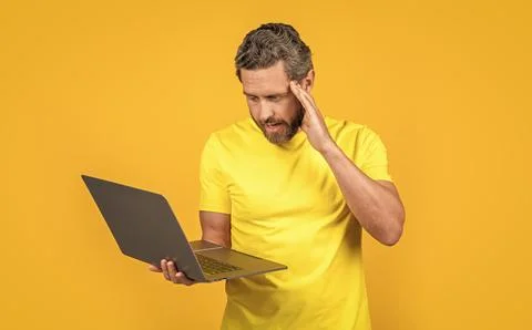 Puzzled man programmer isolated on yellow. man programmer on background. Stock Photos