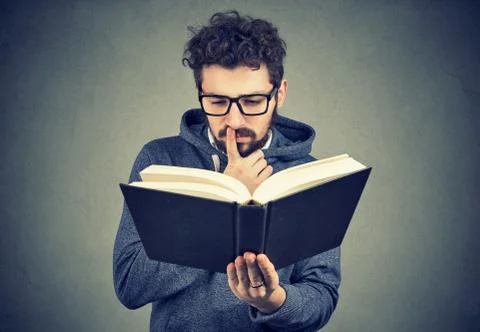 Puzzled man reading a book Stock Photos