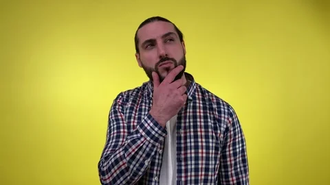Puzzled man seeking solution, resolve problem isolated on yellow Stock Footage 236043200
