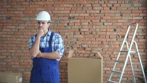 A puzzled man in a working uniform finds a solution Stock Footage 99537636