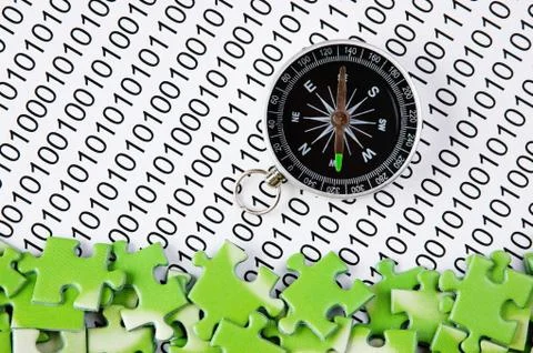 Puzzles and compass on a binary code 스톡 사진