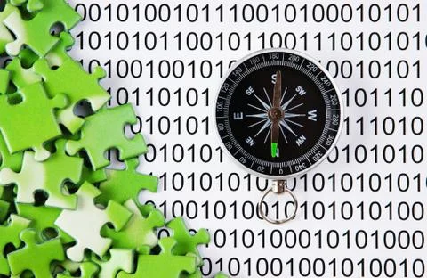 Puzzles and compass on a binary code 库存照片