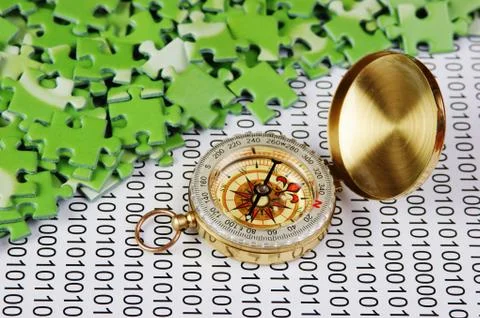Puzzles and compass on a binary code Foto stock