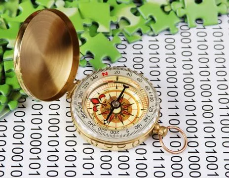 Puzzles and compass on a binary code Foto stock