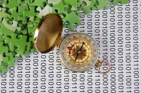 Puzzles and compass on a binary code 库存照片