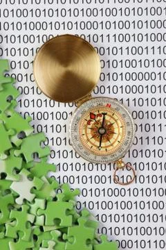 Puzzles and compass on a binary code 库存照片