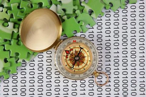 Puzzles and compass on a binary code 写真素材