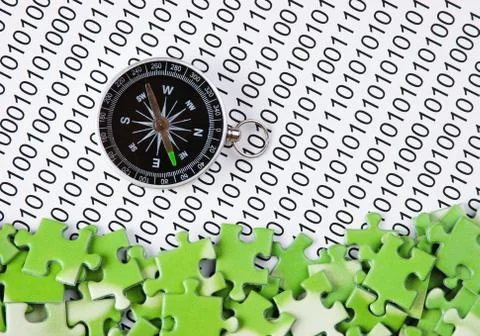 Puzzles and compass on a binary code 写真素材