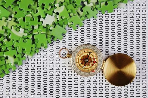 Puzzles and compass on a binary code Foto stock