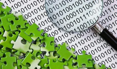 Puzzles and magnifying glass on a binary code Foto stock
